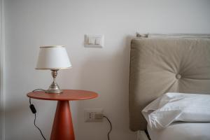 a table with a lamp on it next to a bed at La Casa di Gylda in Milan