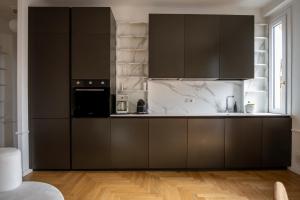 a kitchen with black cabinets and a black appliance at La Casa di Gylda in Milan