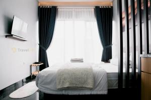 a bedroom with a bed and a large window at Stigma Kubus By Travelink in Kejajar