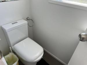a bathroom with a white toilet in a room at 5 Bedroom House A with 13 Beds including 6 Double Beds, 2 Single Beds, and 5 Sofa Beds in Auckland +33 photos
