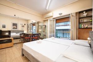 a bedroom with two beds and a dining room at Syntagma square 1 bedrm 4 persons apartment by MPS in Athens