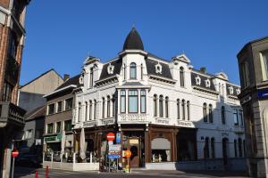 ein großes weißes Gebäude in einer Stadtstraße in der Unterkunft Hotel Grupello in Geraardsbergen