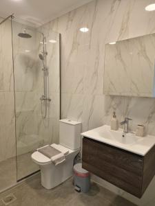 a bathroom with a toilet and a sink and a shower at George Studios in Alepou +5 photos