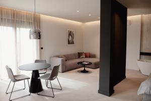 a living room with a couch and a table and chairs at Sobe Six On 7 - Luxury Apartments & Rooms in Slavonski Brod