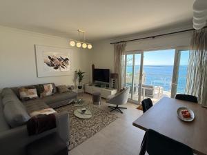 a living room with a couch and a table at Estepona Beach Front Apartment with Stunning Sea Views in Estepona