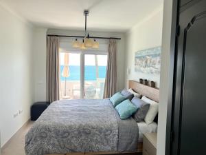 a bedroom with a bed with a view of the ocean at Estepona Beach Front Apartment with Stunning Sea Views in Estepona