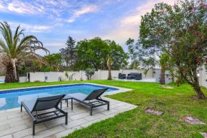 a backyard with a swimming pool and two lawn chairs at The Serenity-Apartment 3 in Sandton +3 photos