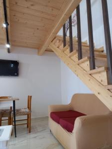 a living room with a couch and wooden stairs at Il borgo nuovo, Pompei in Terzigno +6 photos