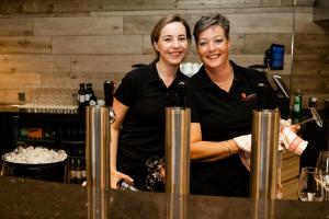 two women standing behind a counter in a kitchen at Wilgenhaege Vakantievilla Wellness in Hellendoorn +39 photos