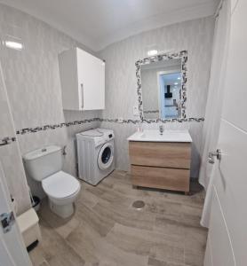 a bathroom with a toilet sink and a washing machine at Castillo Apartament in Torremolinos
