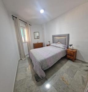 a bedroom with a bed and a table and a window at Castillo Apartament in Torremolinos