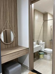 a bathroom with a sink and a mirror and a toilet at Chi Homestay Nera Garden Huế in Hue