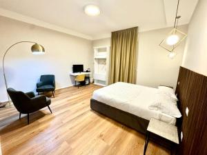 a bedroom with a bed and a desk and a chair at Tenuta Lo Cuoccio in Gravina in Puglia