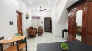 a living room with a table and some chairs at De Banyan Fort Homestay in Cochin