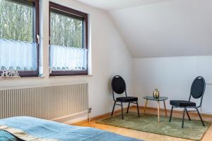a bedroom with two chairs and a table at Fewo Naturblick in Wiesenthau +14 photos