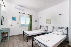 two beds in a room with a window at Varagoulis Giannis & Lenas Apartments in Paramonas