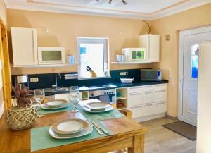 a kitchen with a table with plates and wine glasses at Lenis Strandhaus in Loissin