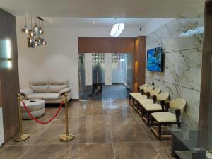 a lobby with a waiting room with a couch and chairs at Hotel Vaishnavi Heights, Solapur in Bāle