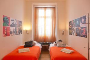 two beds in a room with orange sheets at Living Lounge Hostel in Lisbon
