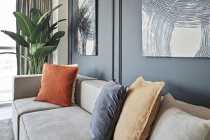 a living room with a couch with pillows on it at Silkhaus Al Reem island Modern 1BDR in Abu Dhabi
