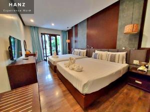 a bedroom with two beds and a flat screen tv at Sunrise Hotel Luang Prabang Mekong river in Luang Prabang
