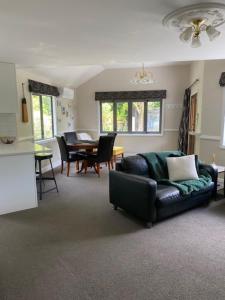 a living room with a couch and a table at Emerald Haven in Upper Hutt