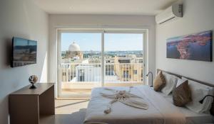 a bedroom with a bed and a large window at Orbis Boutique Studios by Holi in Qormi +32 photos