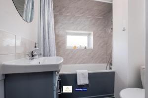 a bathroom with a sink and a tub and a toilet at Centrally Located 3 Bedroom House By Trinity Stays Short Lets & Serviced Accommodation Cambridge in Cambridge +25 photos