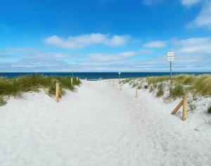 a white sand path leading to the beach at Madlen in Ahrenshoop