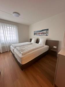 a bedroom with a large bed with white sheets at Swiss Star Zurich Airport - Self Check-In in Kloten