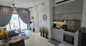 uma cozinha e sala de estar com um sofá e uma mesa em Seabreeze 1BR Suite with Gorgeous Infinity Pool em Kuala Lumpur
