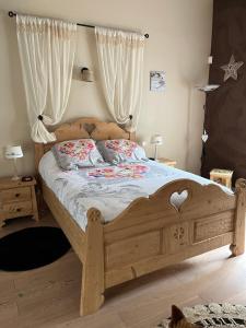 a bedroom with a wooden bed with two pillows at Agréables chambres au calme in Nîmes