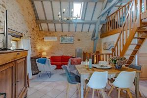 ein Wohnzimmer mit einem Tisch, Stühlen und einem roten Sofa in der Unterkunft Villa charmante à Beynac-et-Cazenac avec piscine privée in Beynac-et-Cazenac