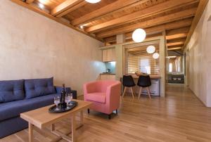 a living room with a blue couch and a pink chair at Polixeny's Suites in Chania