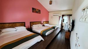 two beds in a room with red walls at 墾丁夏旅Villa-可包棟 in Daguang