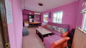 a living room with pink walls and a purple couch at 墾丁夏旅Villa-可包棟 in Daguang +16 photos