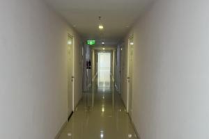 an empty hallway with white walls and a long aisle at Green Pramuka by Uchi Property in Jakarta