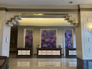 Eine Lobby mit drei Fenstern und violetten Gemälden an den Wänden in der Unterkunft Morrian Hotel in Inegol