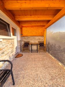a screened in porch with two chairs and a table at Apartment Teja in Brezovec
