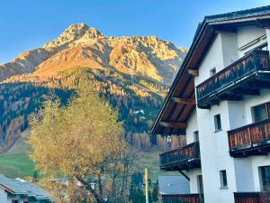 um edifício com uma montanha ao fundo em Cosy studio apartment in Splügen em Splügen