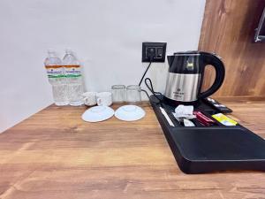 una licuadora sentada en un mostrador con vasos y botellas de agua en Hotel Omkar Palace, en Ayodhya