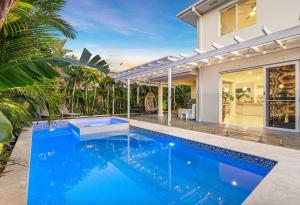 a swimming pool in front of a house at Family Wellness Retreat in Kingscliff