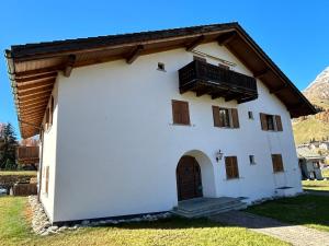 um edifício branco com uma varanda em cima em Cosy studio apartment in Splügen em Splügen