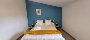 a bedroom with a large bed with a blue wall at Mer Méditerranée et Béziers à 10min Parking gratuit in Sauvian
