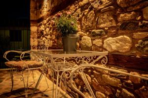 a table with a potted plant on a stone wall at ΣΟΧΟΣ ΠΑΡΑΔΟΣΙΑΚΕΣ ΟΙΚΙΕΣ - Σαχνισί in Zokhós