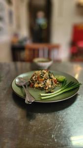 a plate of food with a fork and a pickle at Yenta4fafad in Ban Na Ta Luang (1)
