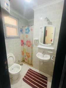 a bathroom with a toilet and a sink and a mirror at بورتو السخنه اكوا بارك in Ain Sokhna