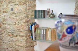 a row of books on shelves on a wall at Guest House Sa Succargia in Baunei