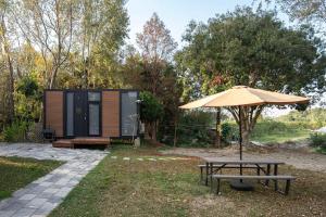 斗六市Gandan Inn 2 by Tiny Away的小屋旁带雨伞的野餐桌