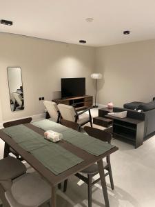 ein Wohnzimmer mit Tisch und Stühlen und einem Fernseher in der Unterkunft Al Salehiyah 2 in Medina